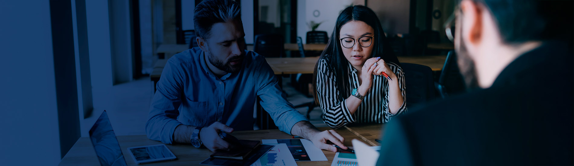 Foto de dos ejecutivos observando unas gráficas en una reunión.