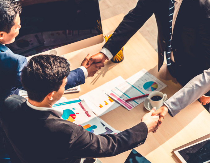Foto de un grupo de ejecutivos estrechándose la mano.