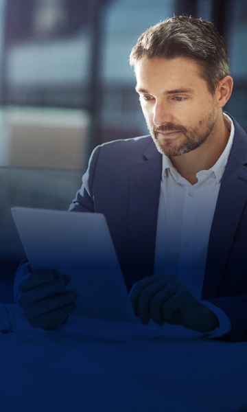 Ejecutivo con tableta en oficina moderna.