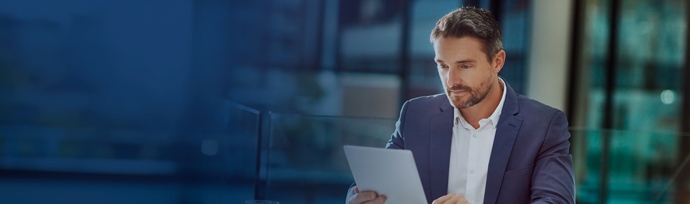 Ejecutivo con tableta en oficina moderna.